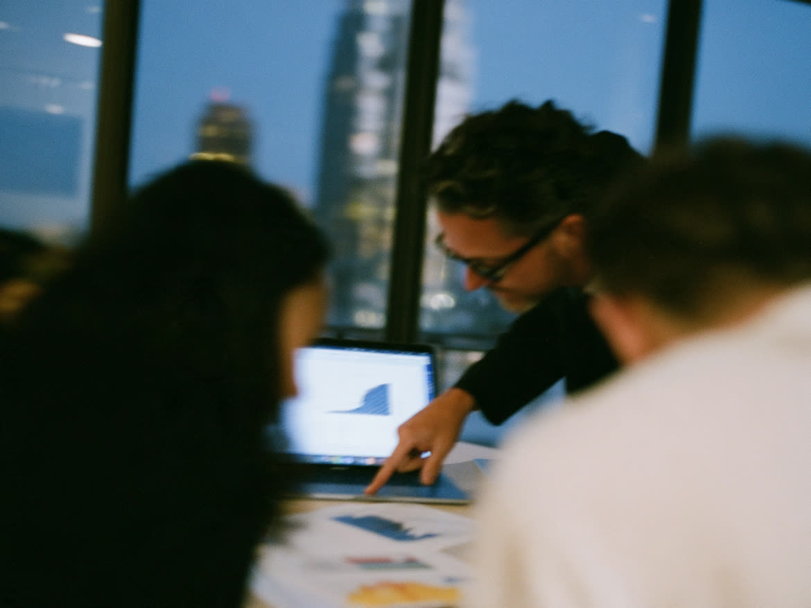Consultants reviewing charts on a laptop at dusk