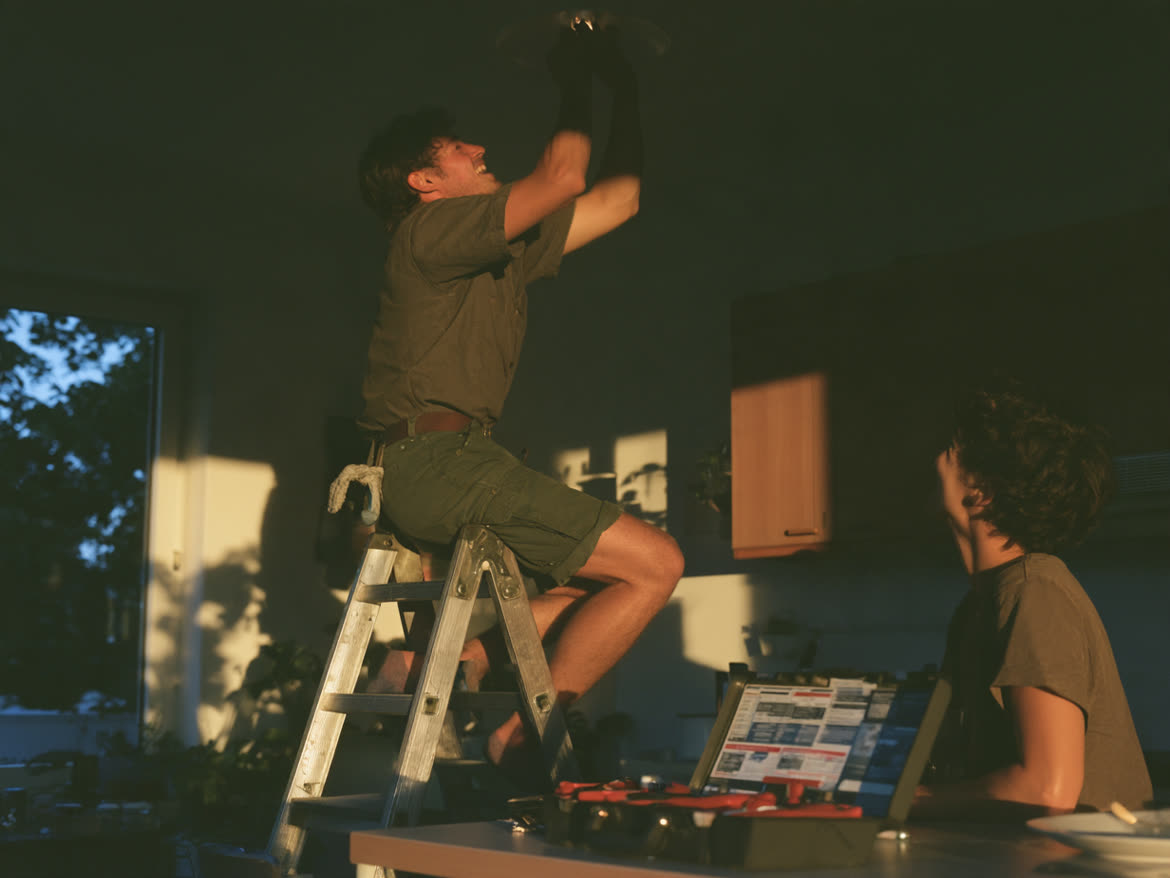 Handyman on a stepladder fixing a ceiling light