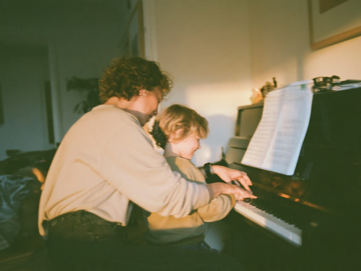 Piano teacher guiding a student's hands on the keys