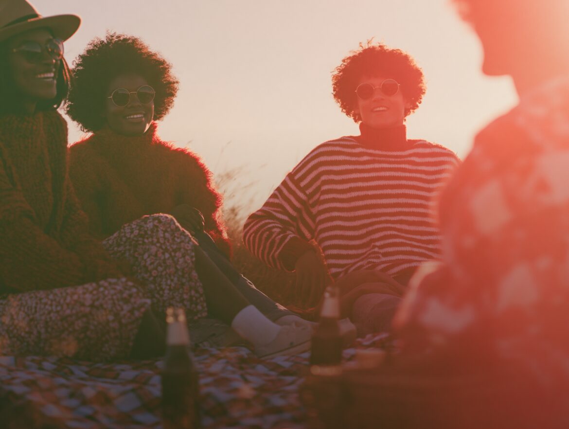Friends gathered together outdoors at sunset
